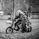 Photo of Gem on bike with two children in carrier behind