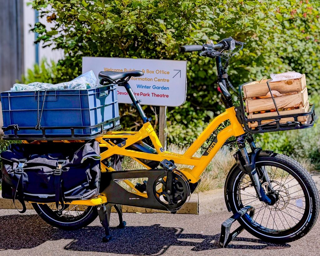 Brighton yellow electric cargo bike with crates in front and back racks,