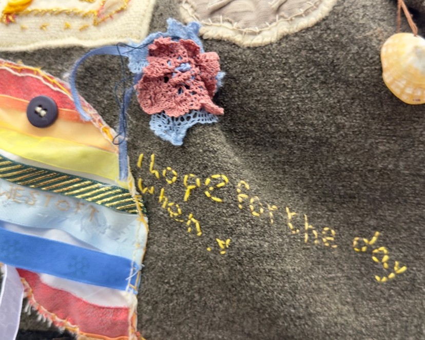 A piece of quilt which is in the process of being sewn. The embroidered messages begins 'I hope for the day when'
